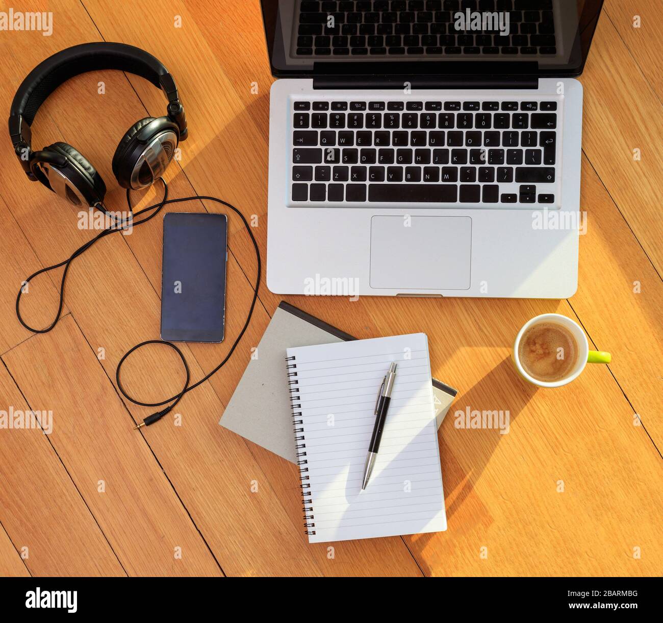 Home office, remote work. Computer laptop, mobile phone, headphones and coffee on the floor. Telecommute, teleworking, work from home Stock Photo