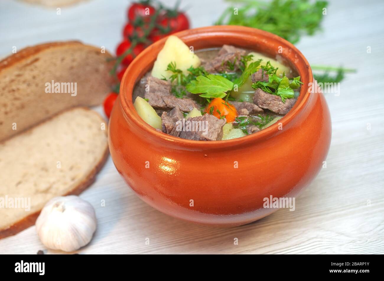 Roast in a pot with beef meat and potatoes on the table Stock Photo