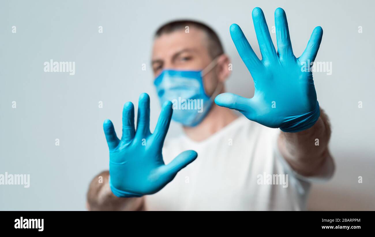 Man In Medical Mask Gesturing Stop Over Gray Background, Panorama Stock Photo