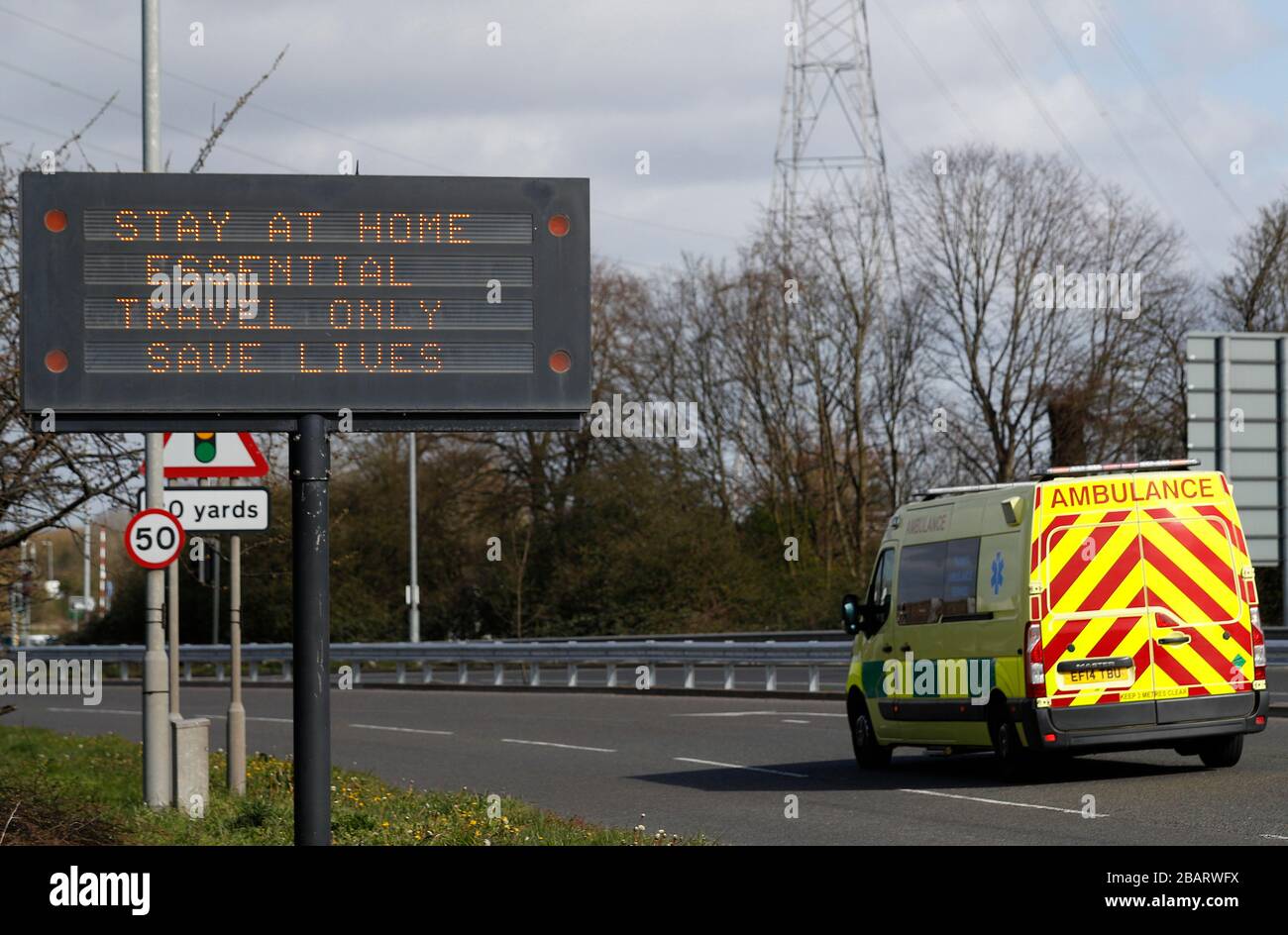 Leicester, Leicestershire, UK. 29th March 2020.  An ambulance is driven past a sign encouraging people to say at home in Leicester during the Coronavirus pandemic. Credit Darren Staples/Alamy Live News. Stock Photo