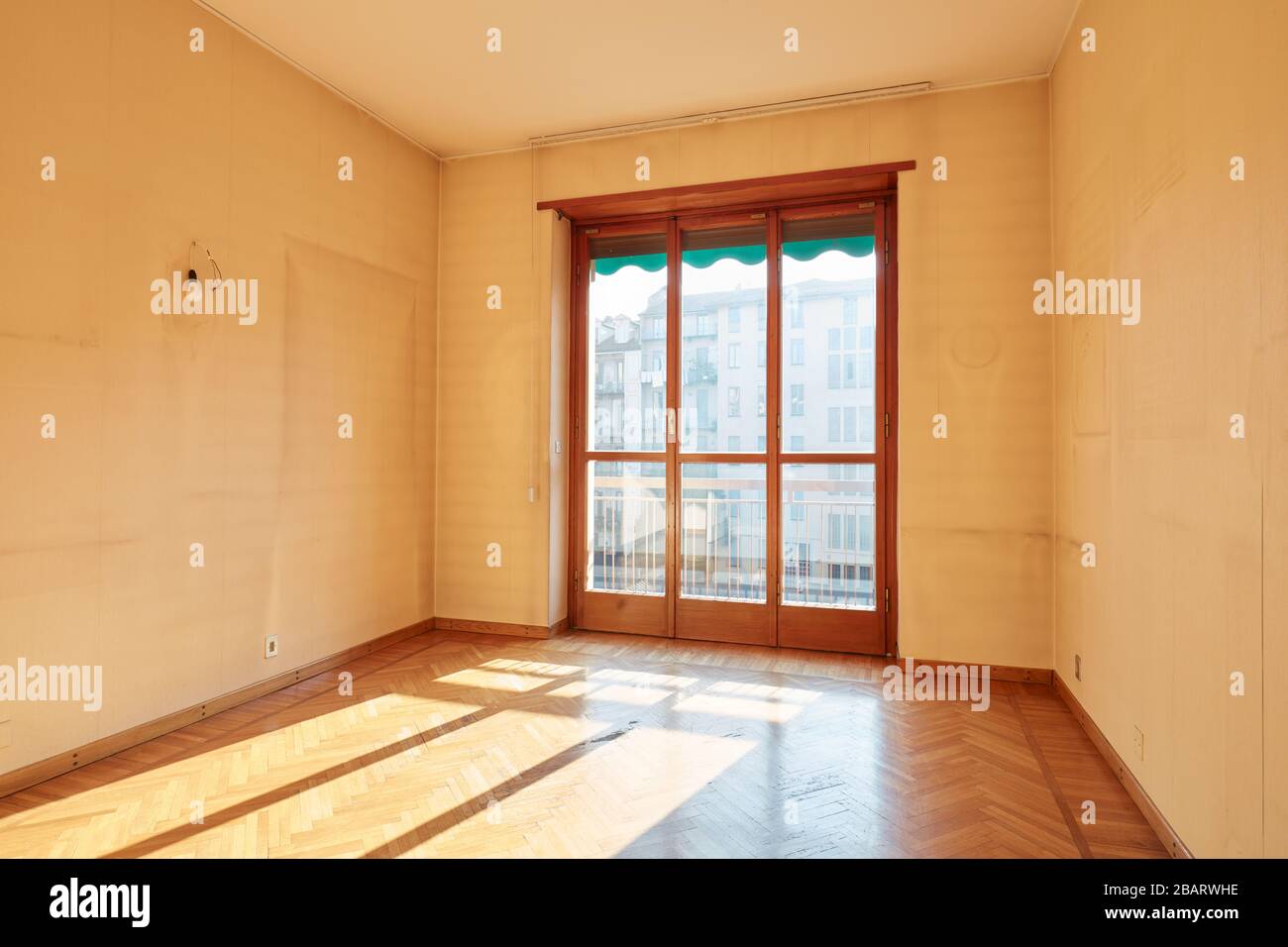 Sunny room with wooden floor in old apartment interior Stock Photo