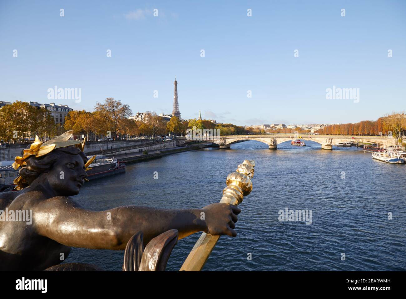 Eiffel tower and Seine river seen in a sunny autumn day from Alexander III bridge, blue sky Paris Stock Photo