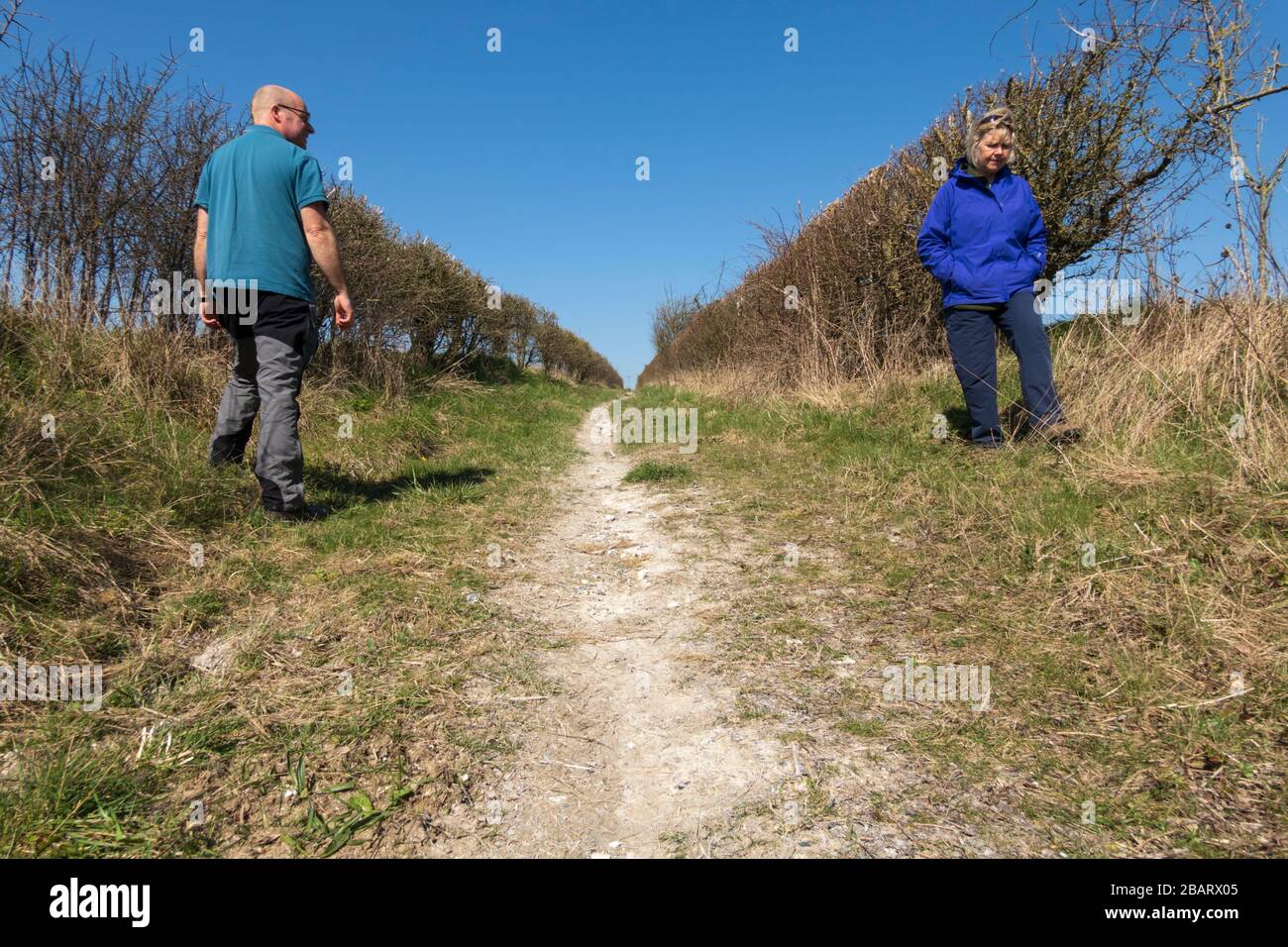 Two walkers keeping a safe distance from each other during coronavirus, East Garston, West Berkshire, England, United Kingdom, Europe Stock Photo