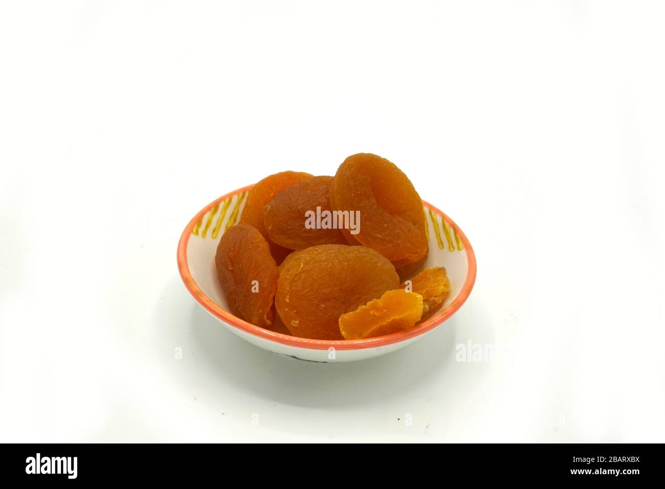 Dried apricots on a ceramic saucer isolated on white background. Energy