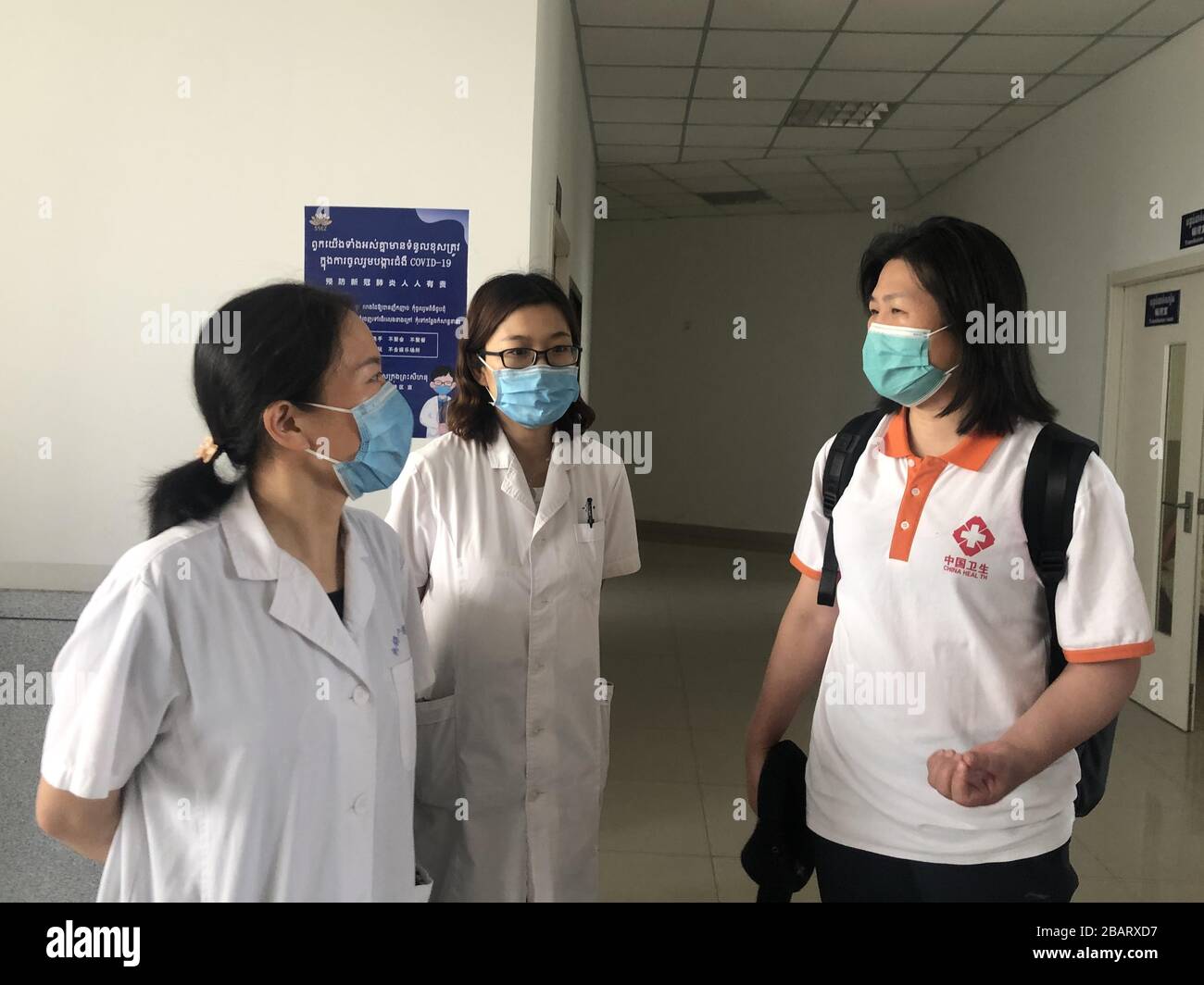 Phnom Penh, Cambodia. 29th Mar, 2020. Huang Luying (R), a Chinese medical expert, communicates with local medical workers at the Sihanoukville Special Economic Zone in Preah Sihanouk province, Cambodia, March 27, 2020. The Chinese medical team landed in Phnom Penh, capital of Cambodia, on March 23 to help combat the epidemic, as the Southeast Asian country has seen a spike in new confirmed cases in recent weeks. Credit: Xinhua/Alamy Live News Stock Photo