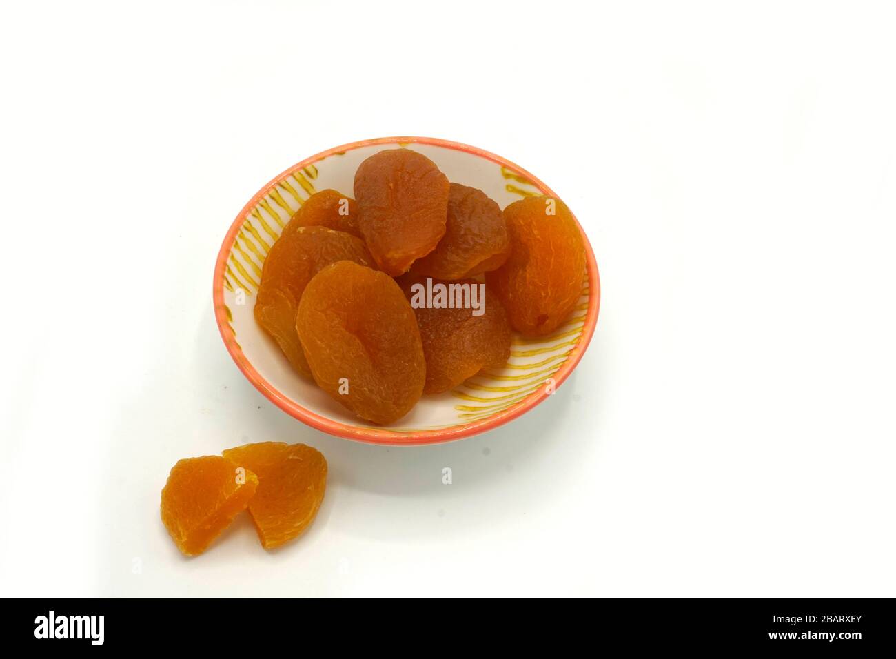 Dried apricots on a ceramic saucer isolated on white background. Energy