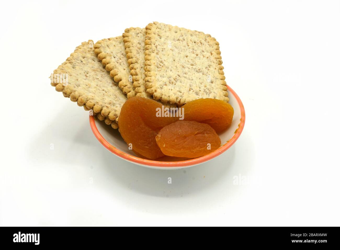 Dried fruits and digestive biscuits on a ceramic saucer isolated on
