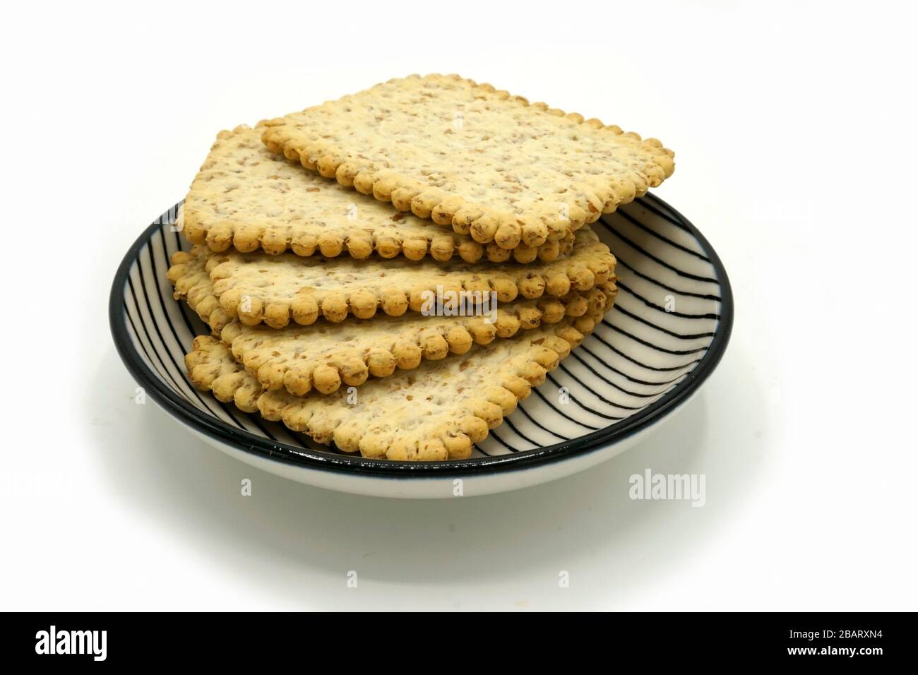 Dried fruits and digestive biscuits on a ceramic saucer isolated on