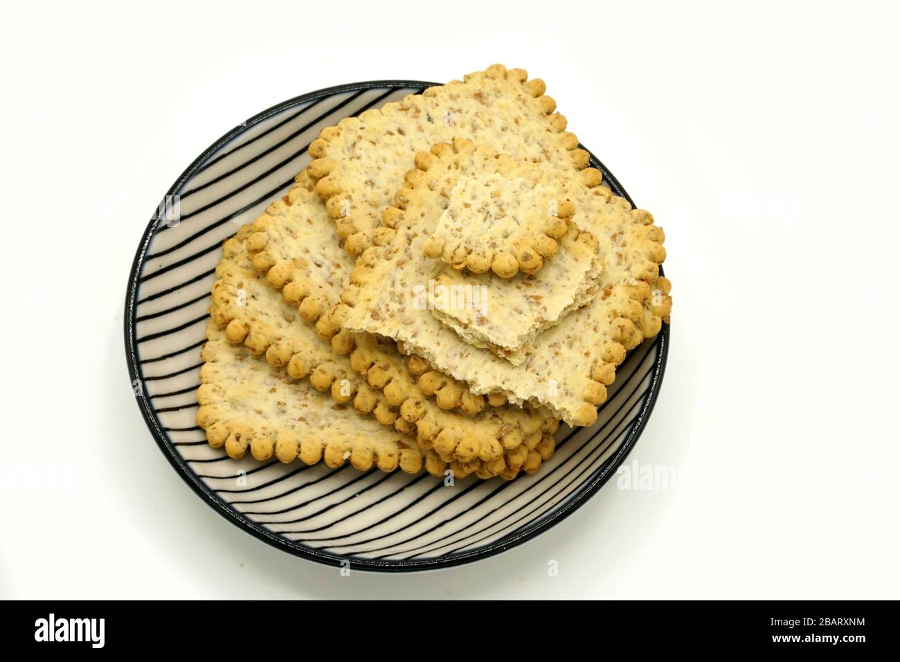Dried fruits and digestive biscuits on a ceramic saucer isolated on