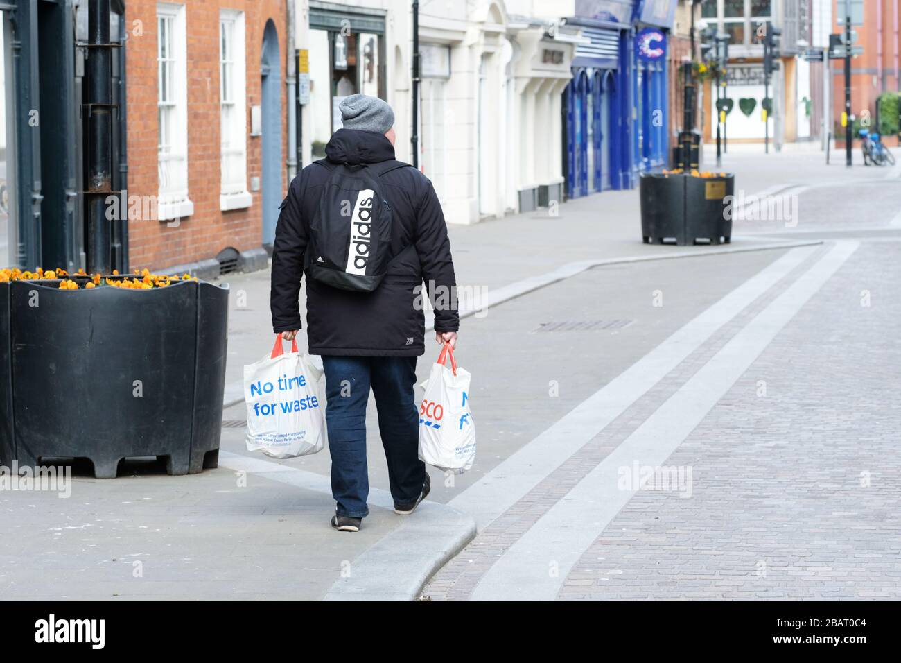 Hereford, Herefordshire, UK - Sunday 29th March 2020 - A shopper walks through a near deserted Hereford city centre with two bags of food shopping on Sunday as lockdown Britain continues into the Coronavirus Covid-19 crisis. Photo Steven May / Alamy Live News Stock Photo