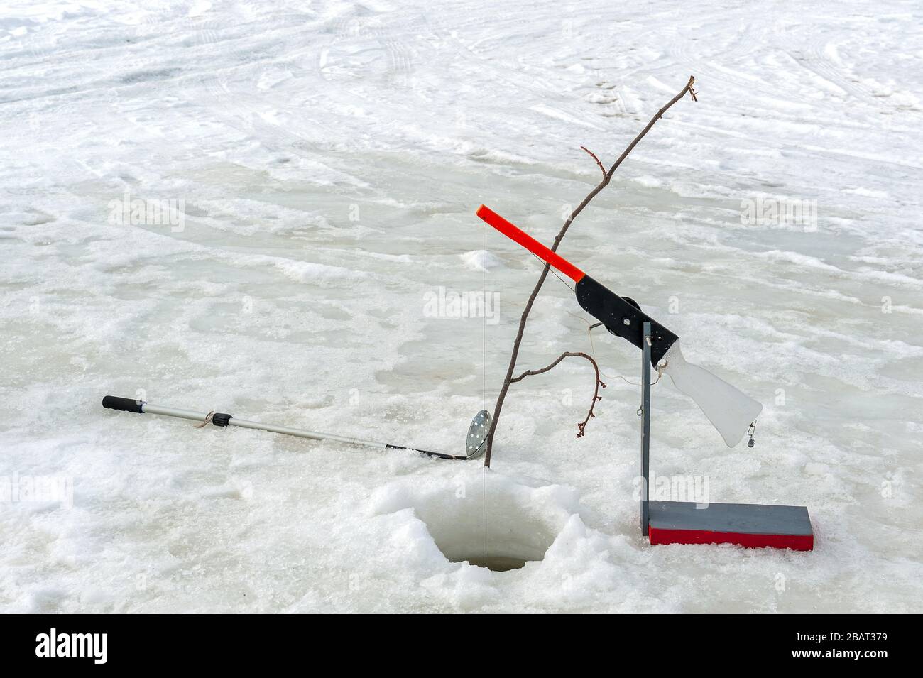 Ice fishing hole and fishing tools Stock Photo