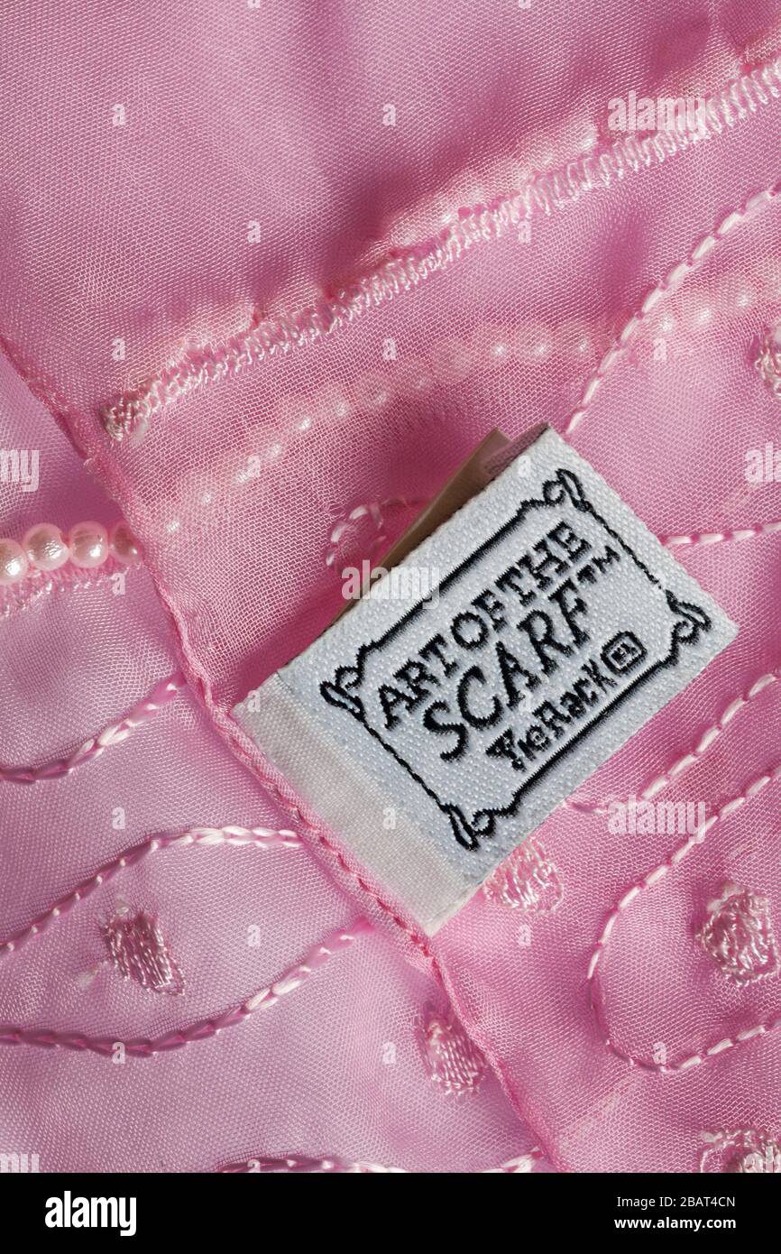 Art of the scarf Tie Rack Label in woman's pink decorative scarf Stock