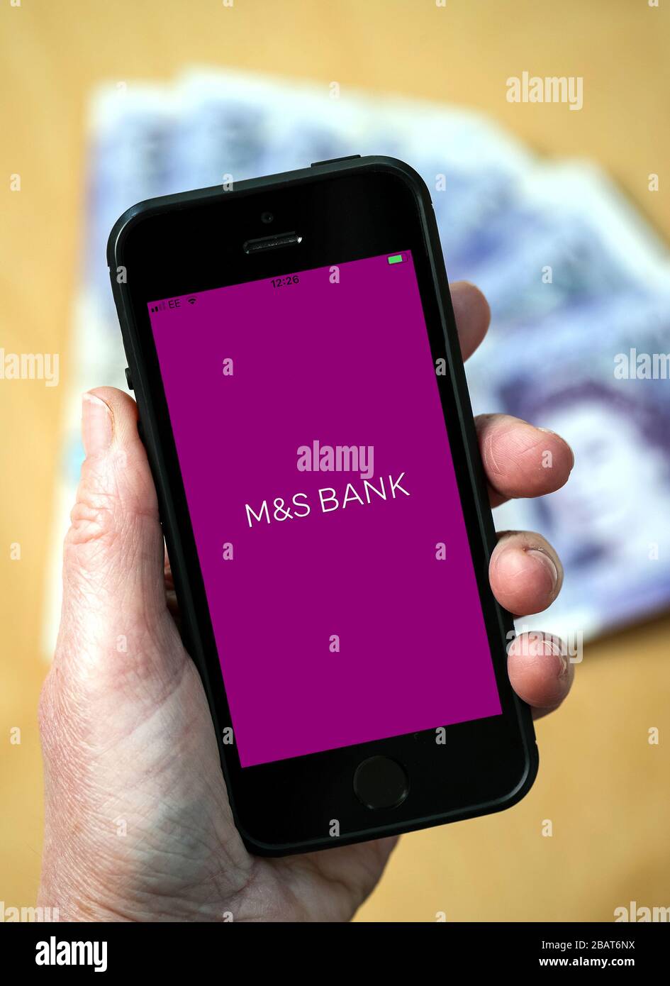 A woman using the M&S Bank app on a mobile phone. (Editorial Use Only) Stock Photo
