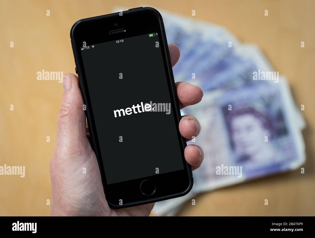 A woman using the mettle accounting app on a mobile phone. (Editorial Use Only) Stock Photo