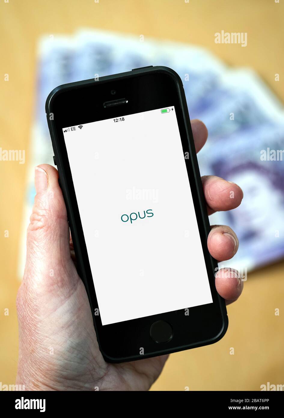 A woman using the Opus credit card app on a mobile phone. (Editorial Use Only) Stock Photo
