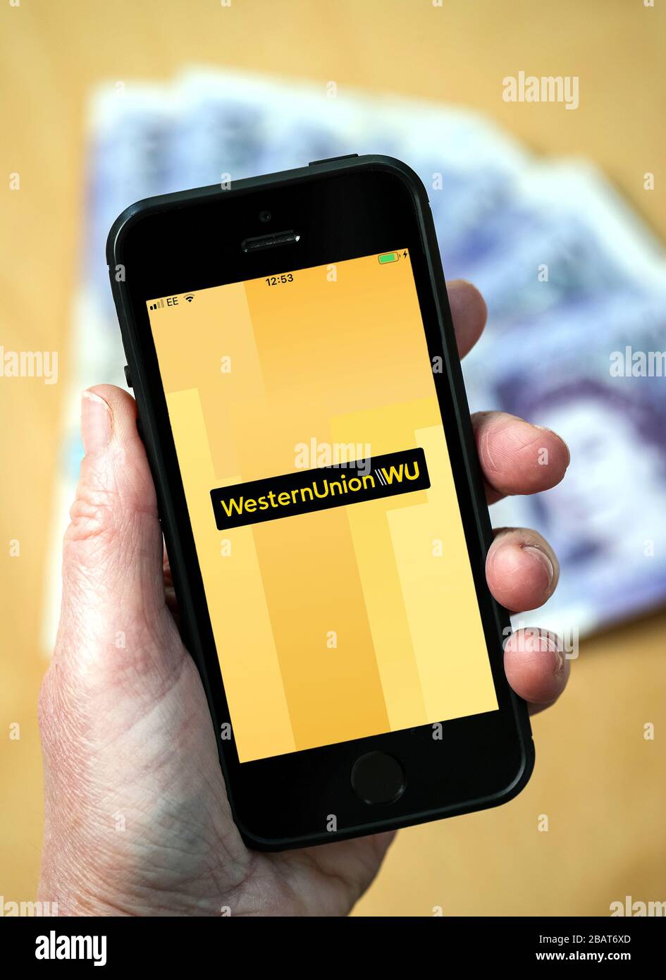 A woman using the Western Union app on a mobile phone. (Editorial Use Only) Stock Photo