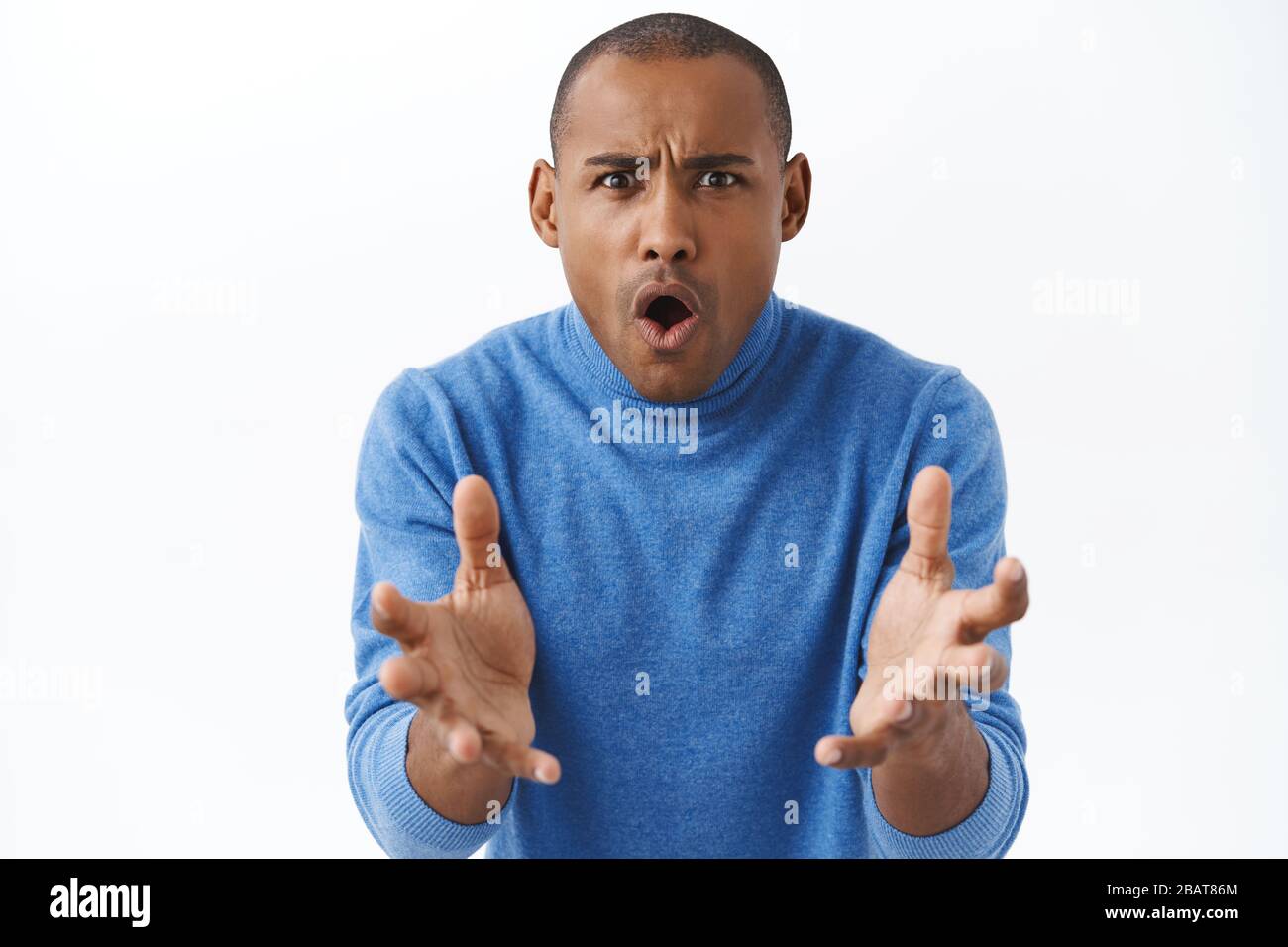 How could you. Portrait of frustrated upset and shocked young african american man reaching hands forward, shake arms and frowning, grimacing angry at Stock Photo