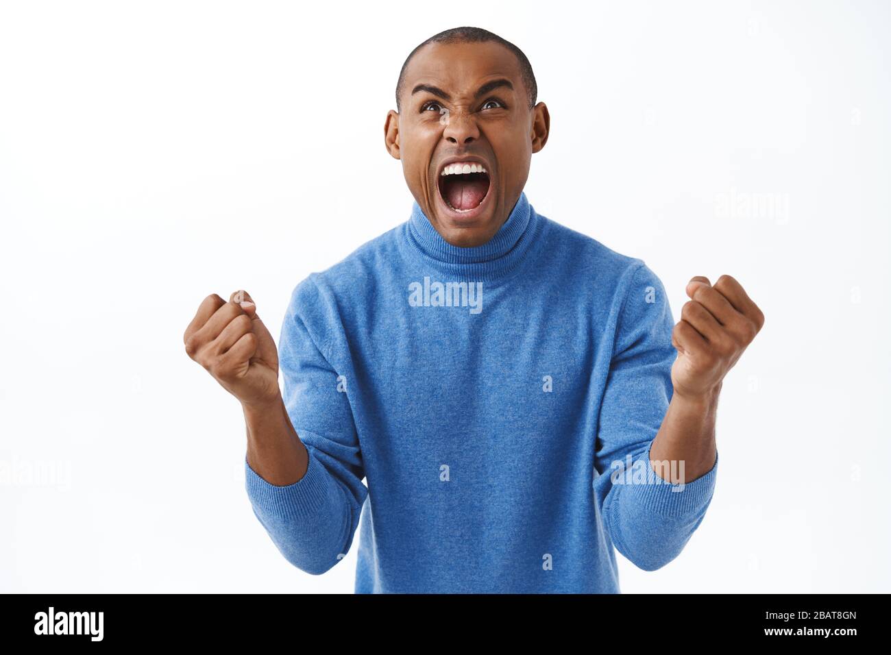Portrait of excited, extremely happy triumphing african american man celebrating goal, watching sports game football, yelling from cheer, rejoicing Stock Photo
