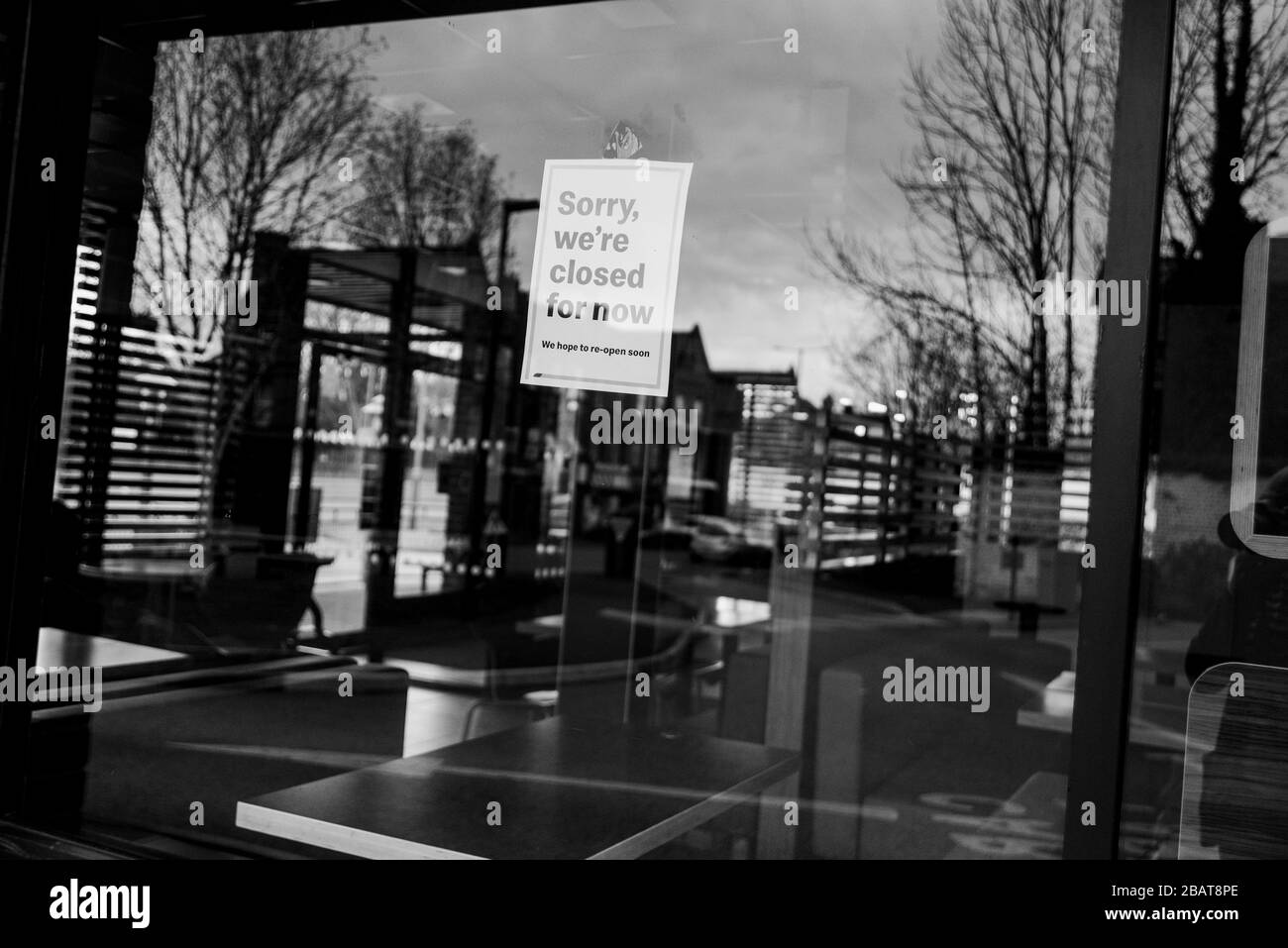 Coronavirus covid19 lockdown UK 2020. Empty, closed down Mcdonalds restaurant. Sign in window saying 'sorry we're closed' Interior seen through window Stock Photo