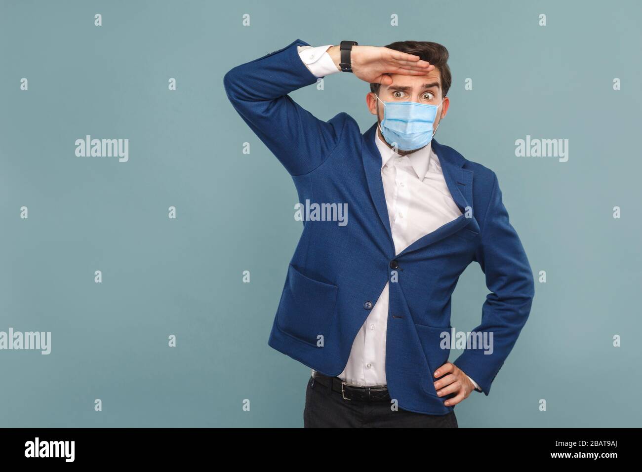 Looking so far with attention. young man with surgical medical mask, serious face looking away. Business people medicine and health care concept. Indo Stock Photo