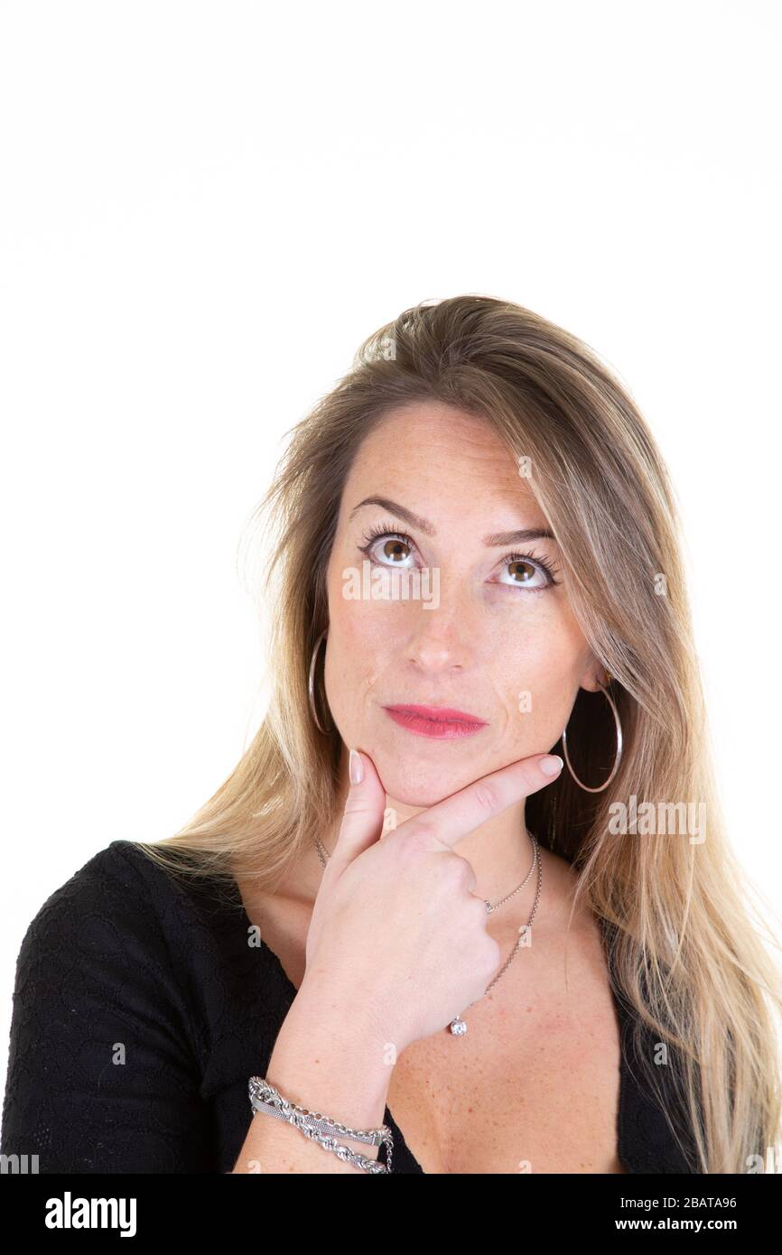 Portrait of a beautiful young blonde woman thinking looking up copy ...