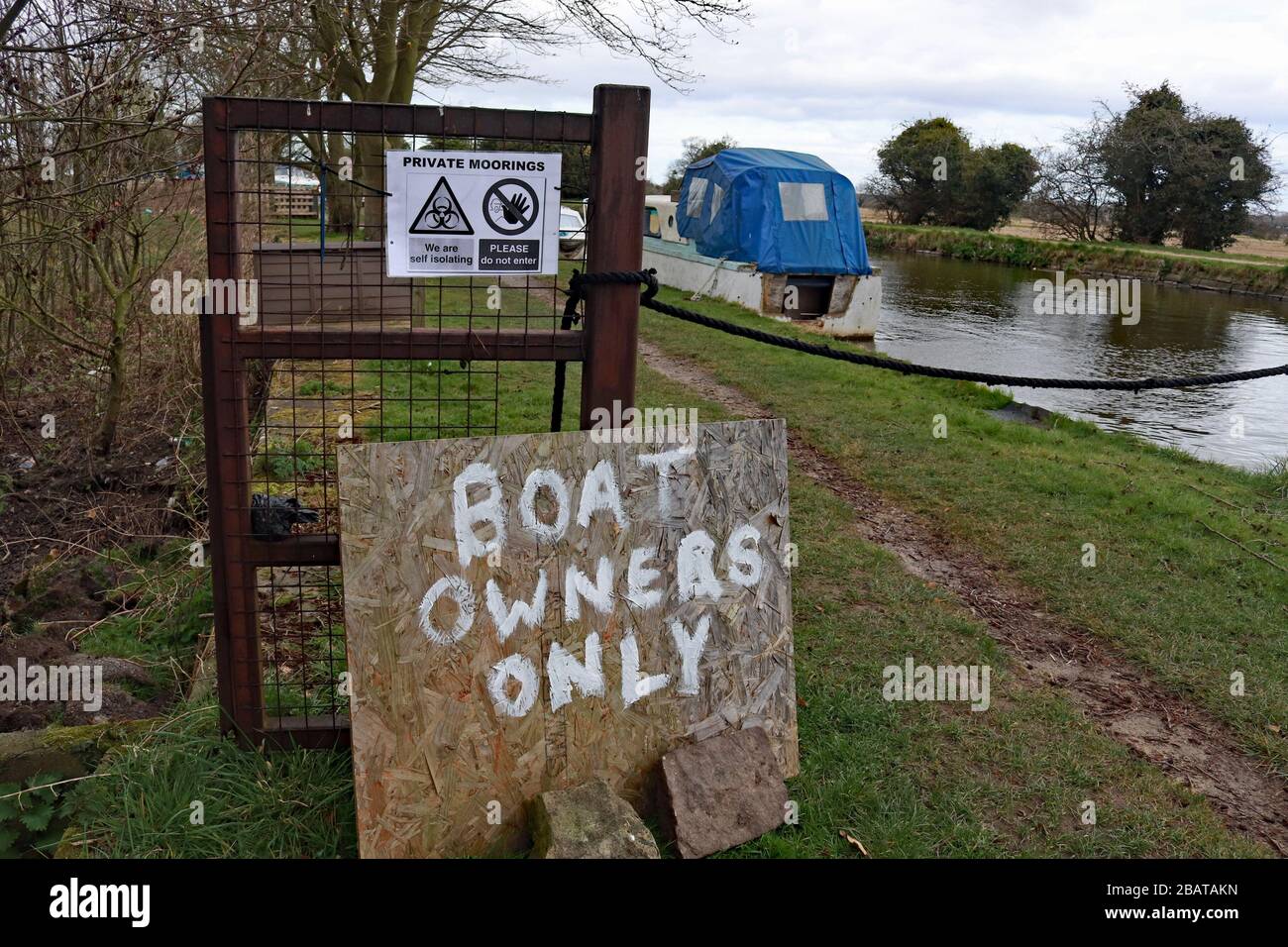 Boat owner’s only homemade sign at entrance to canal moorings where boaters are concerned that the path is not wide enough to prevent social contact Stock Photo