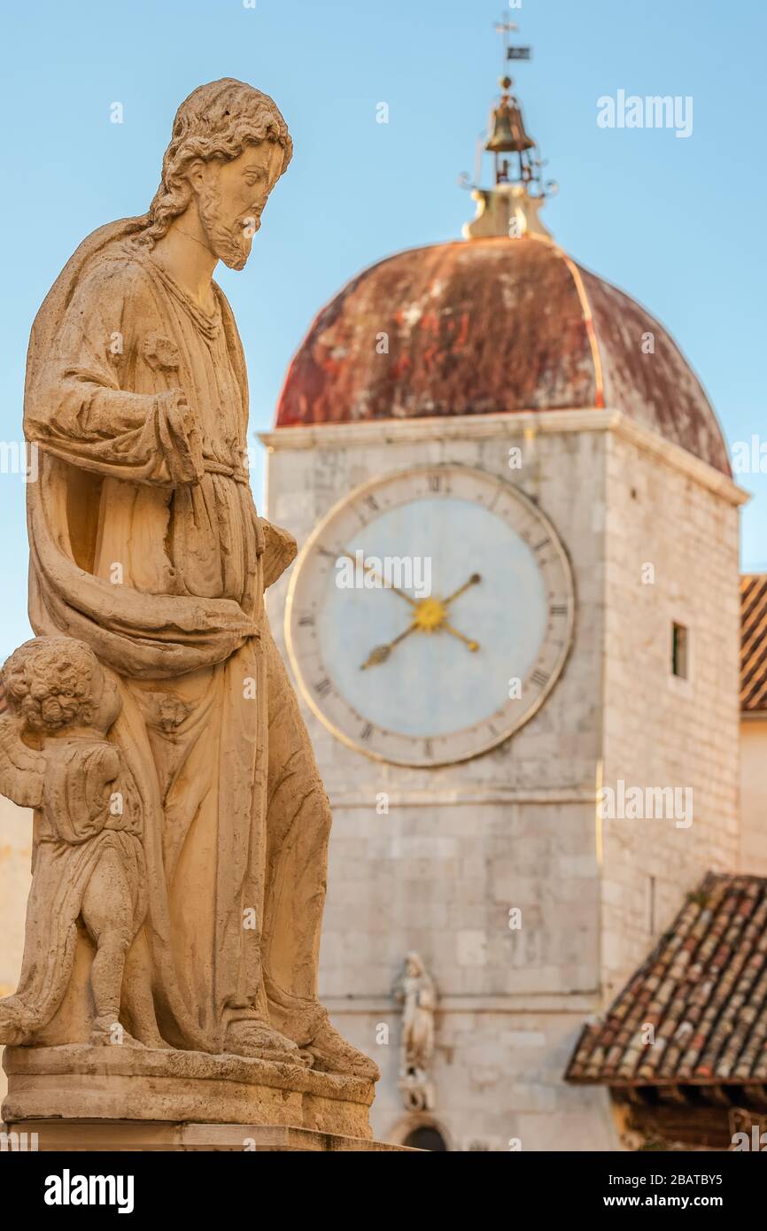 Statue of St Lawrence with Clock tower at background in Trogir, Croatia Stock Photo