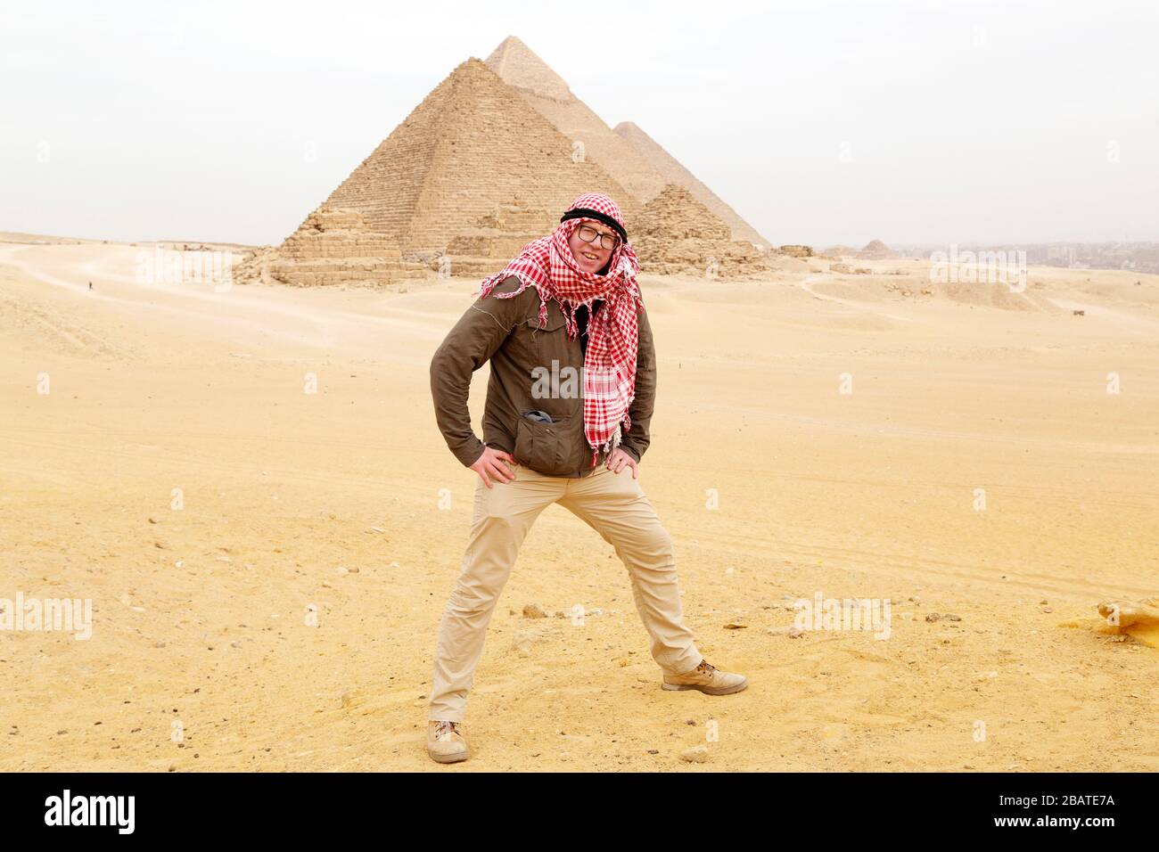 A tourist stands in the desert wearing a traditional Middle-Eastern ...