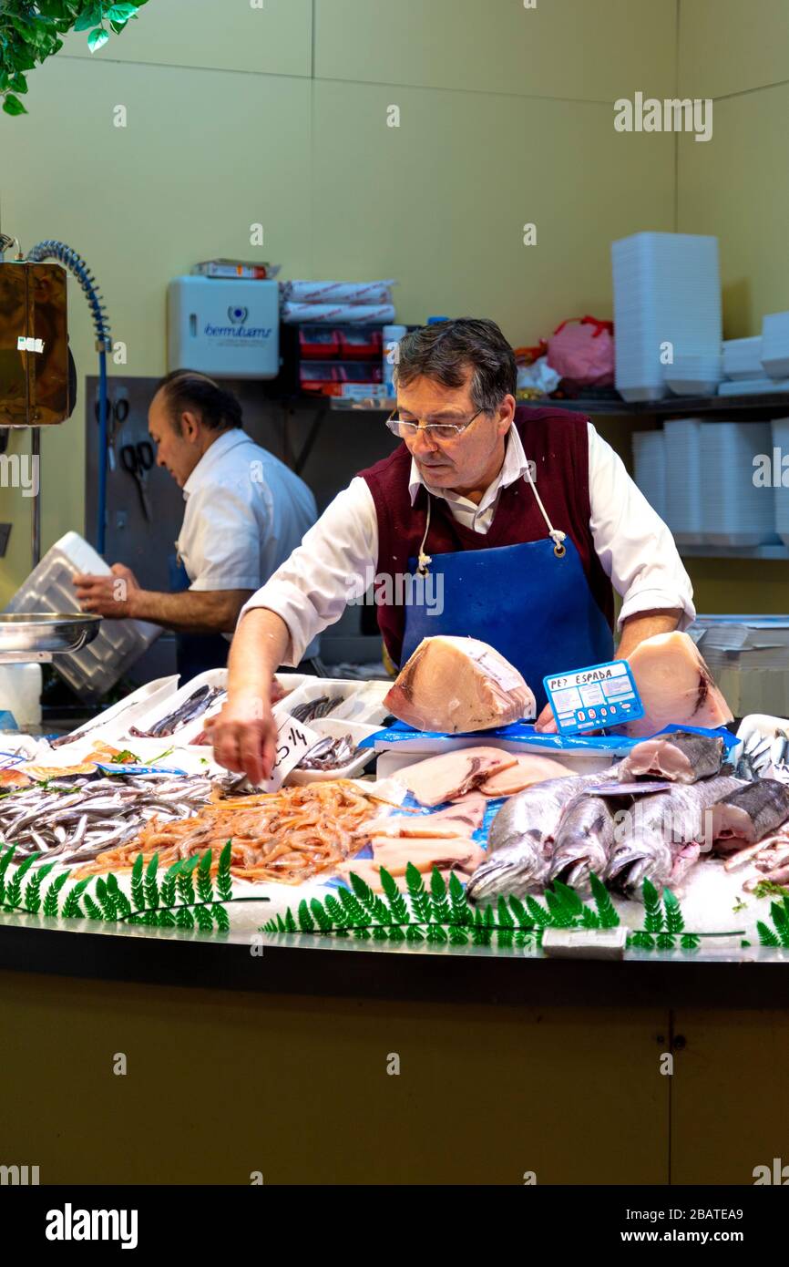 Man tending to fish stall at Mercado de la Encarnacion, Seville, Andalusia, Spain Stock Photo