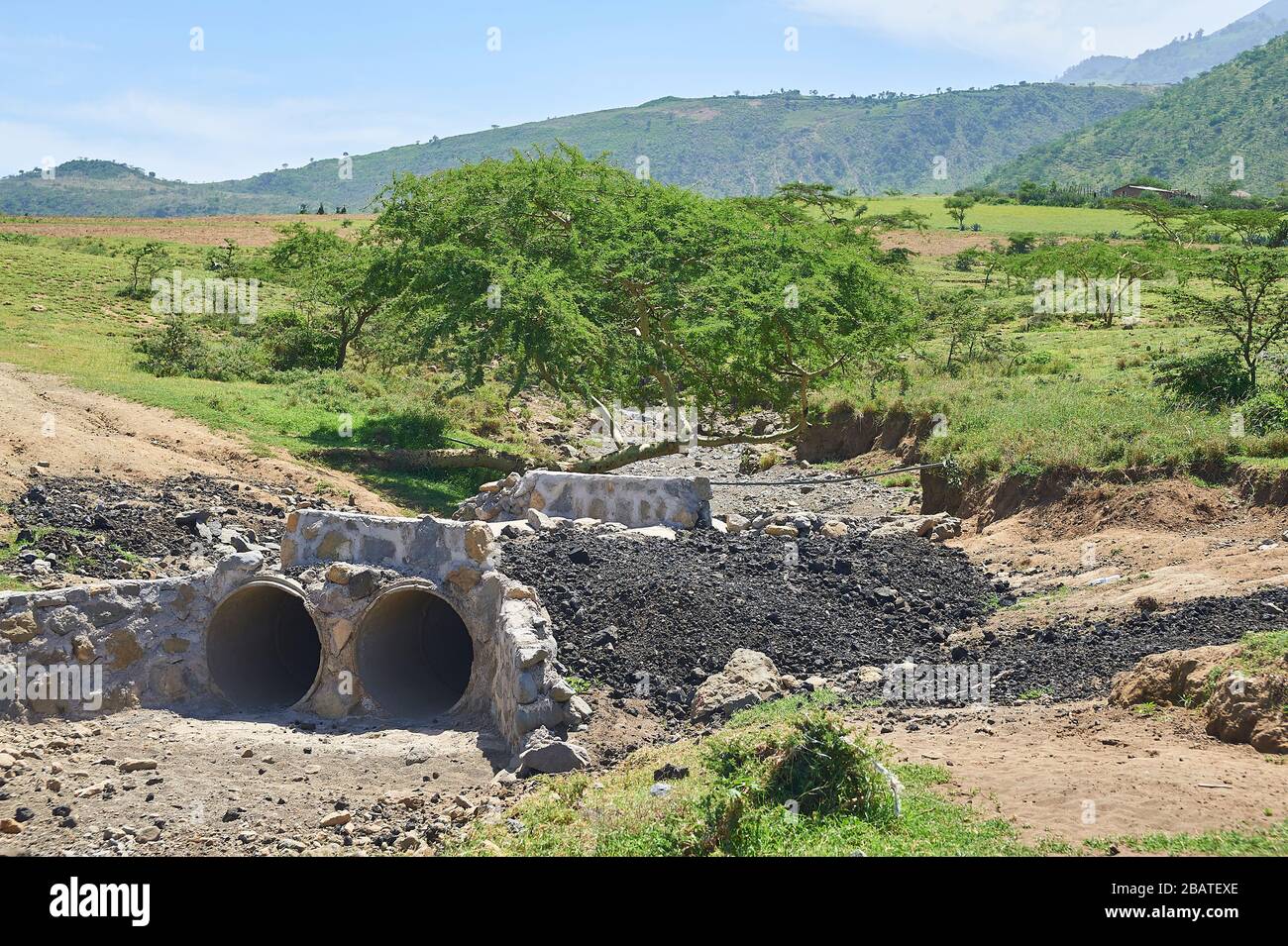 Typical African dirt roadwith culverts washed out after the rain Stock Photo