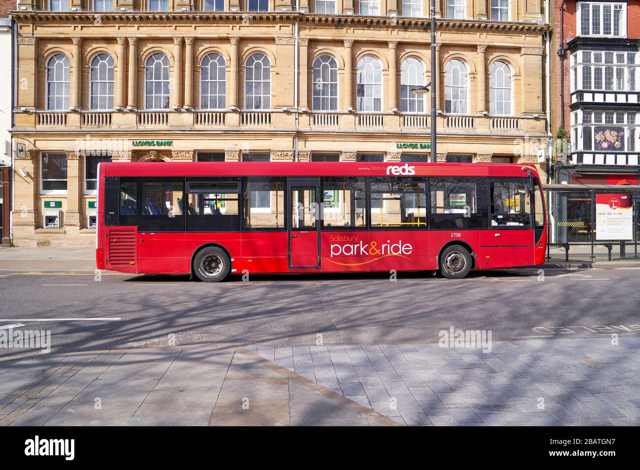 Empty single deck red park and ride service bus waiting at bus stop during the Covid-19 Coronavirus emergency Stock Photo