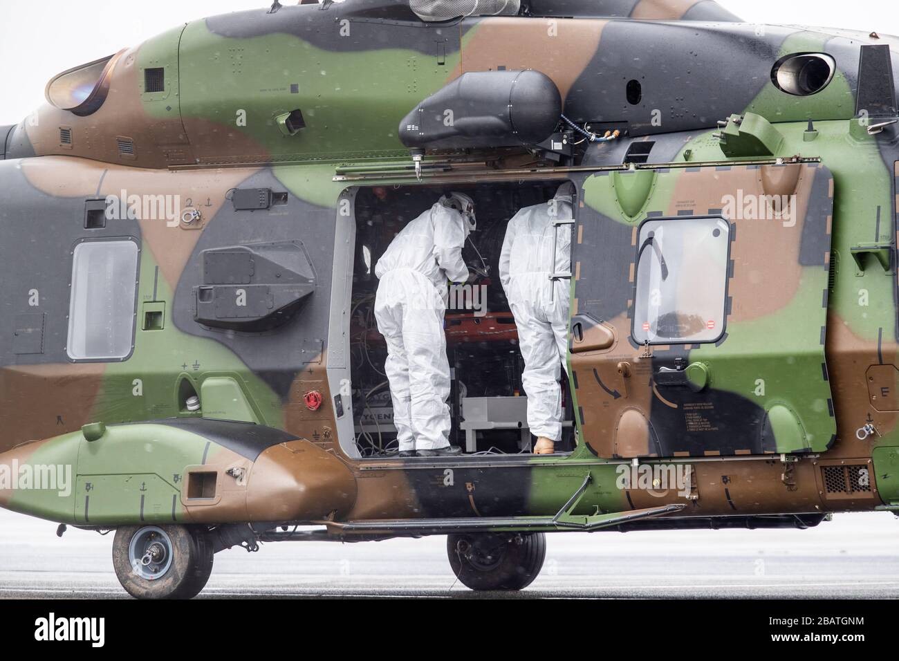 29 March 2020, North Rhine-Westphalia, Mülheim an der Ruhr: Rescue workers in protective clothing stand in a military helicopter at the airport. With this helicopter two patients were brought from Metz in France to Mühlheim to be treated in the university hospital in Essen. Photo: Marcel Kusch/dpa Stock Photo