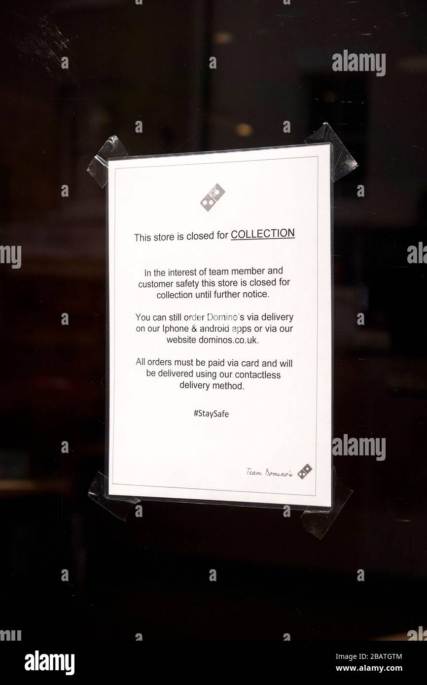Customer notice in Domino's pizza takeaway window advising they are closed for collections but that they can still deliver orders Stock Photo