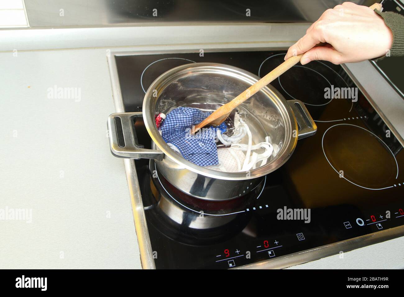 The detail of boiling of home made provisional textile masks to remove all the bacteria and viruses like coronavirus. Stock Photo