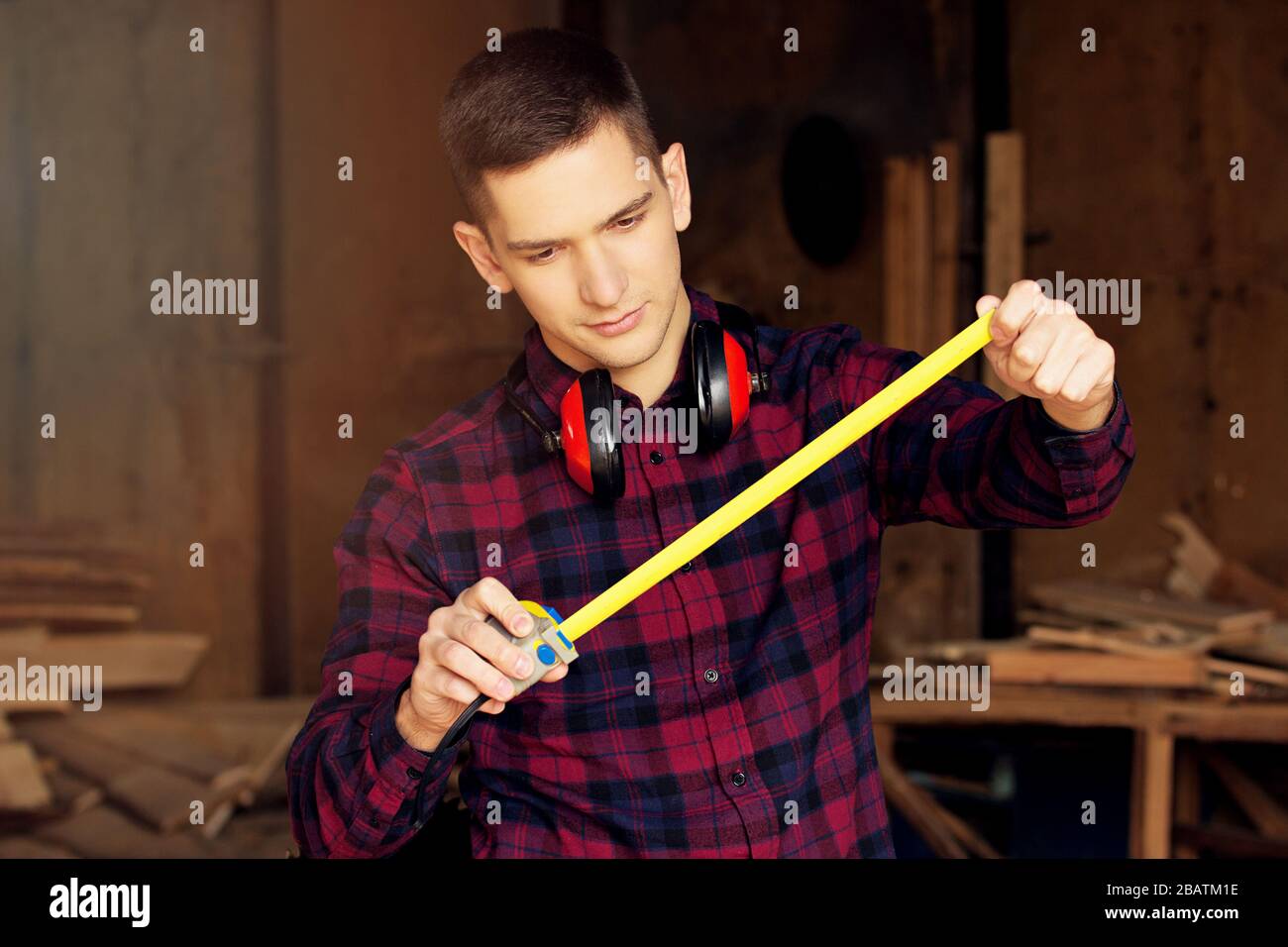 Workman at the sawmill. Young hardworking man Stock Photo