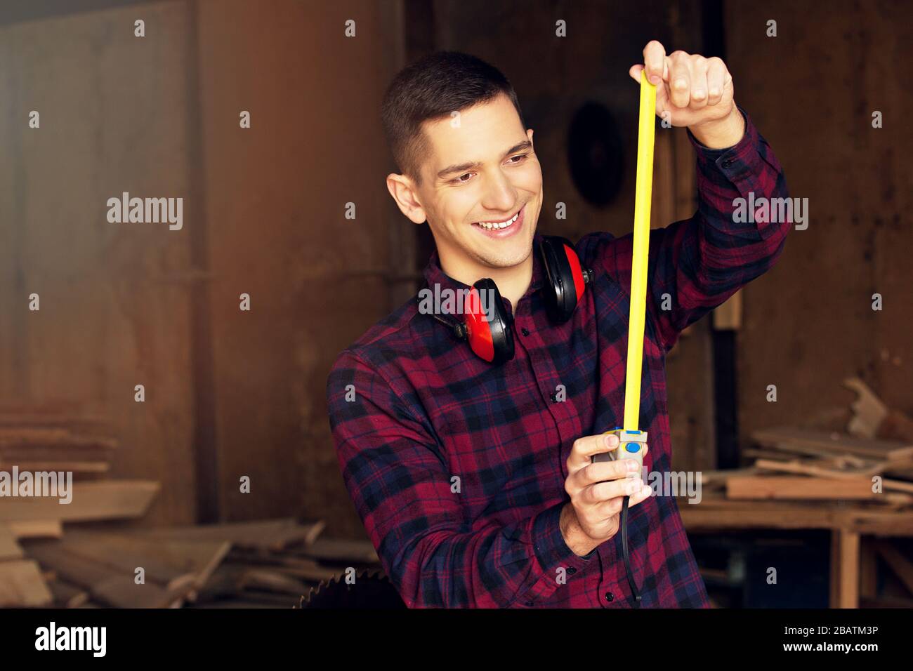 Workman at the sawmill. Young hardworking man Stock Photo