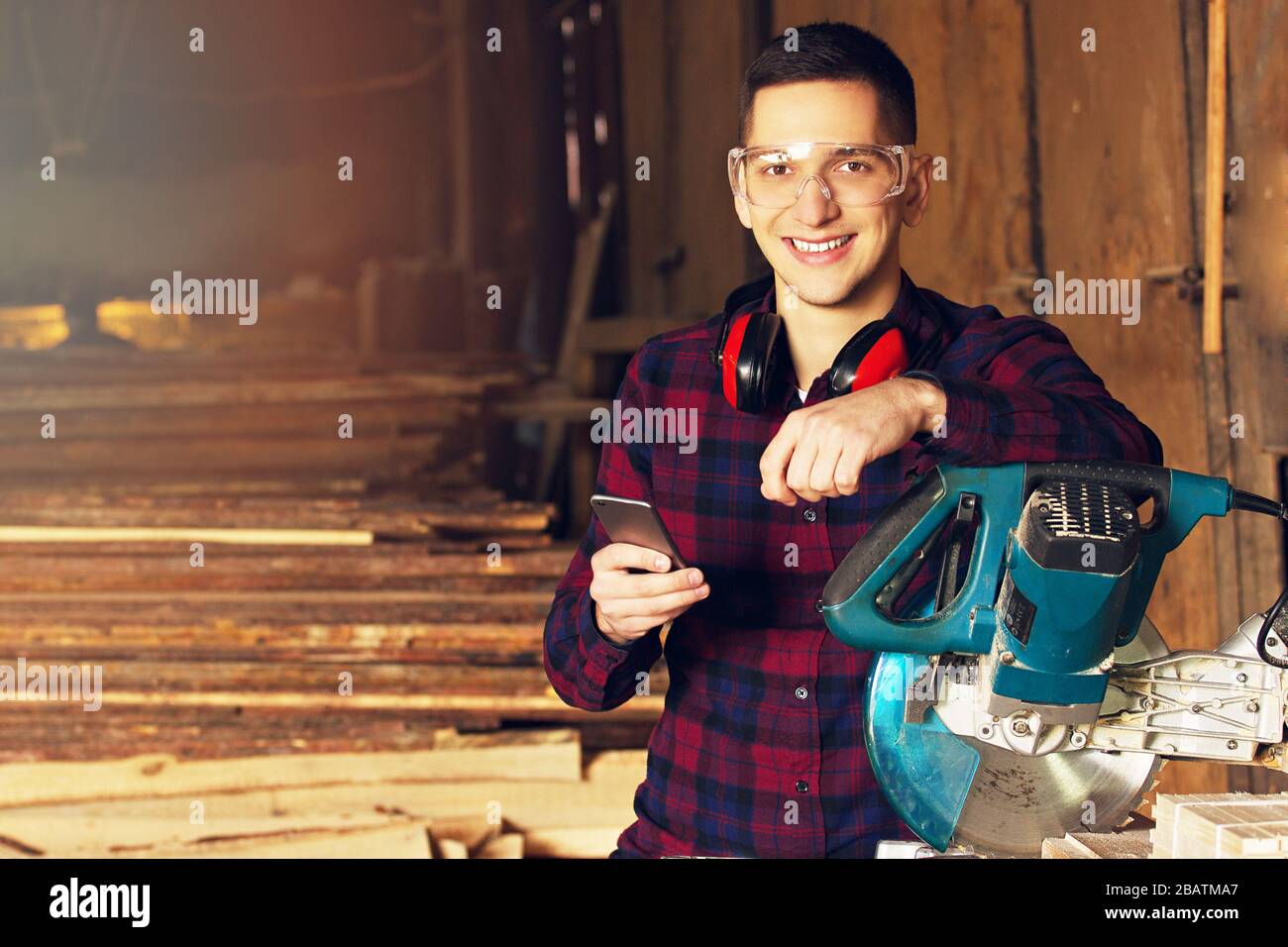 Workman at the sawmill. Young hardworking man Stock Photo