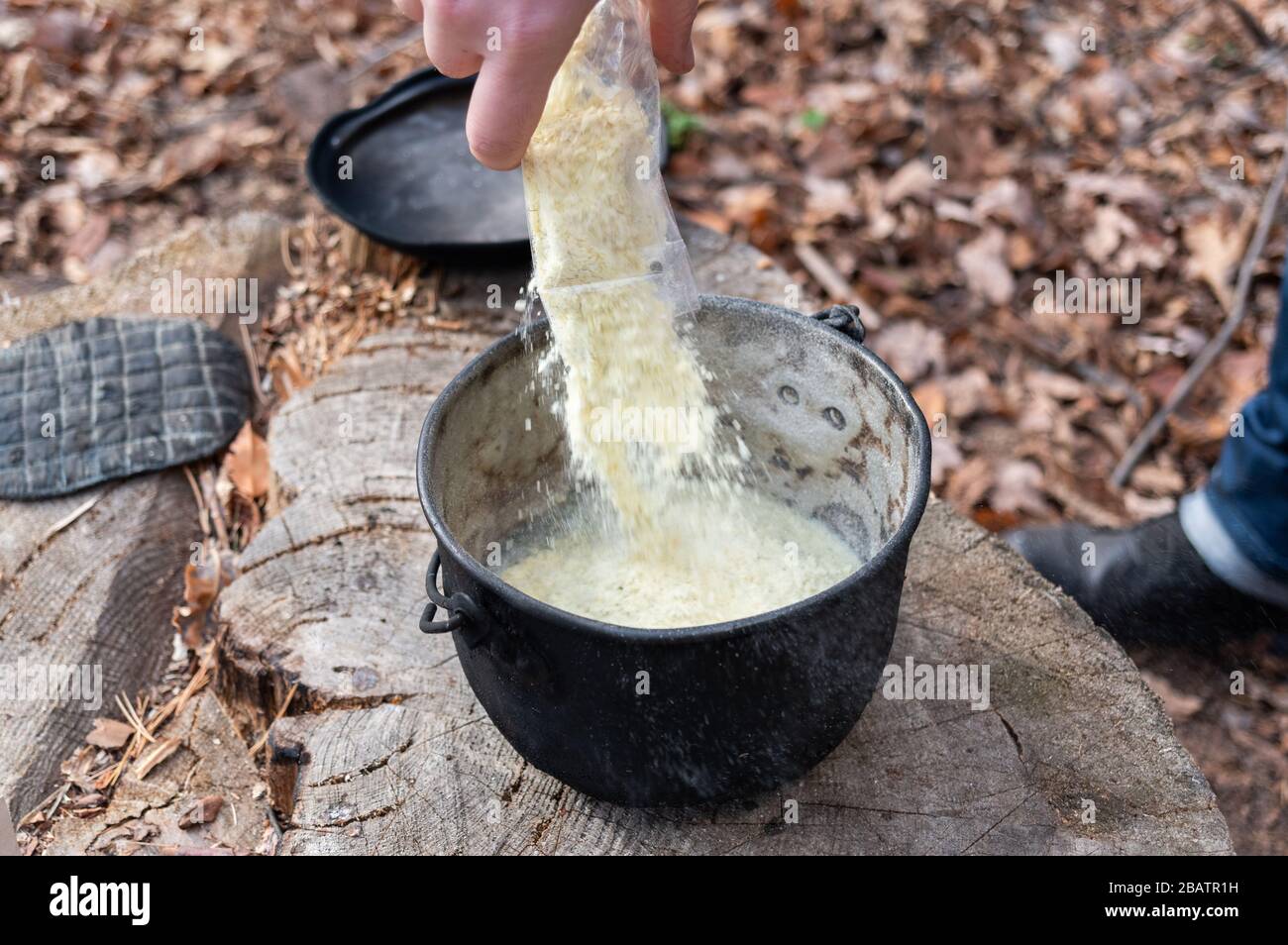 Pour spices and seasoning into the pot. Cooking on the street in an