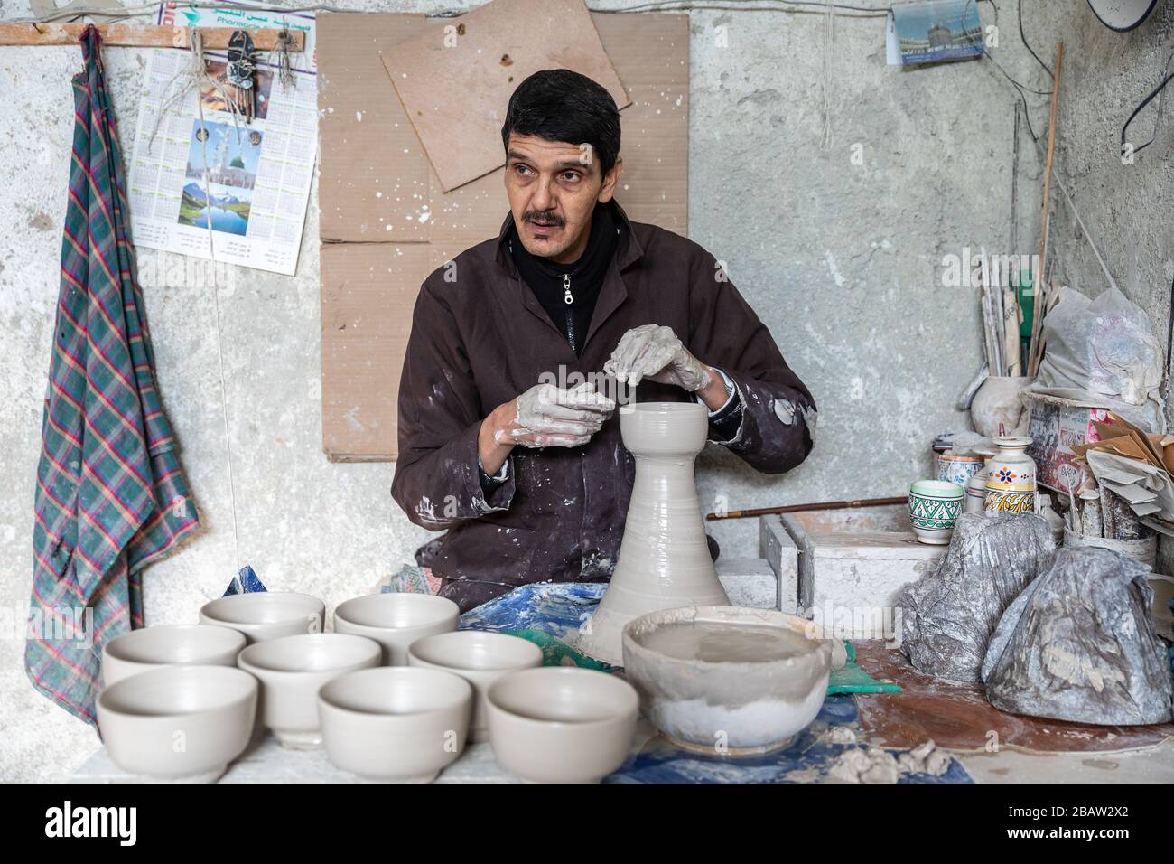 A potter makes ceramic pots at Art Naji pottery factory, Fes, Morocco