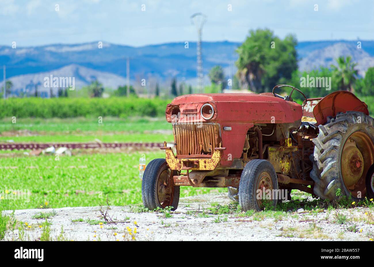 Vieux tracteur rouillé abandonné couvert de mauvaises herbes et les orties  dans farm field Photo Stock - Alamy