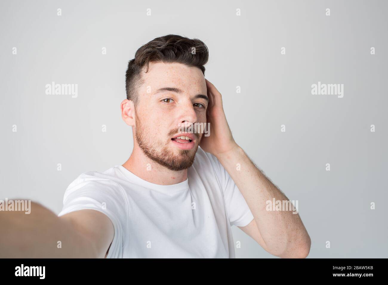 Young man isolated over background. Guy hold camera and take selfie ...