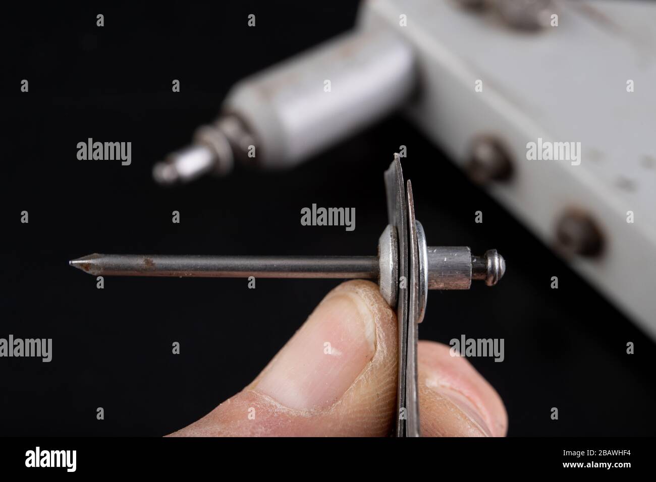 Riveting two pieces of metal sheet. Connecting steel with rivets. Dark ...