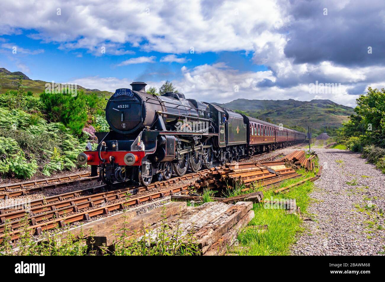 The Jacobite steam train approaches Arisaig railway station at Arisaig in the West Highlands of Scotland Stock Photo