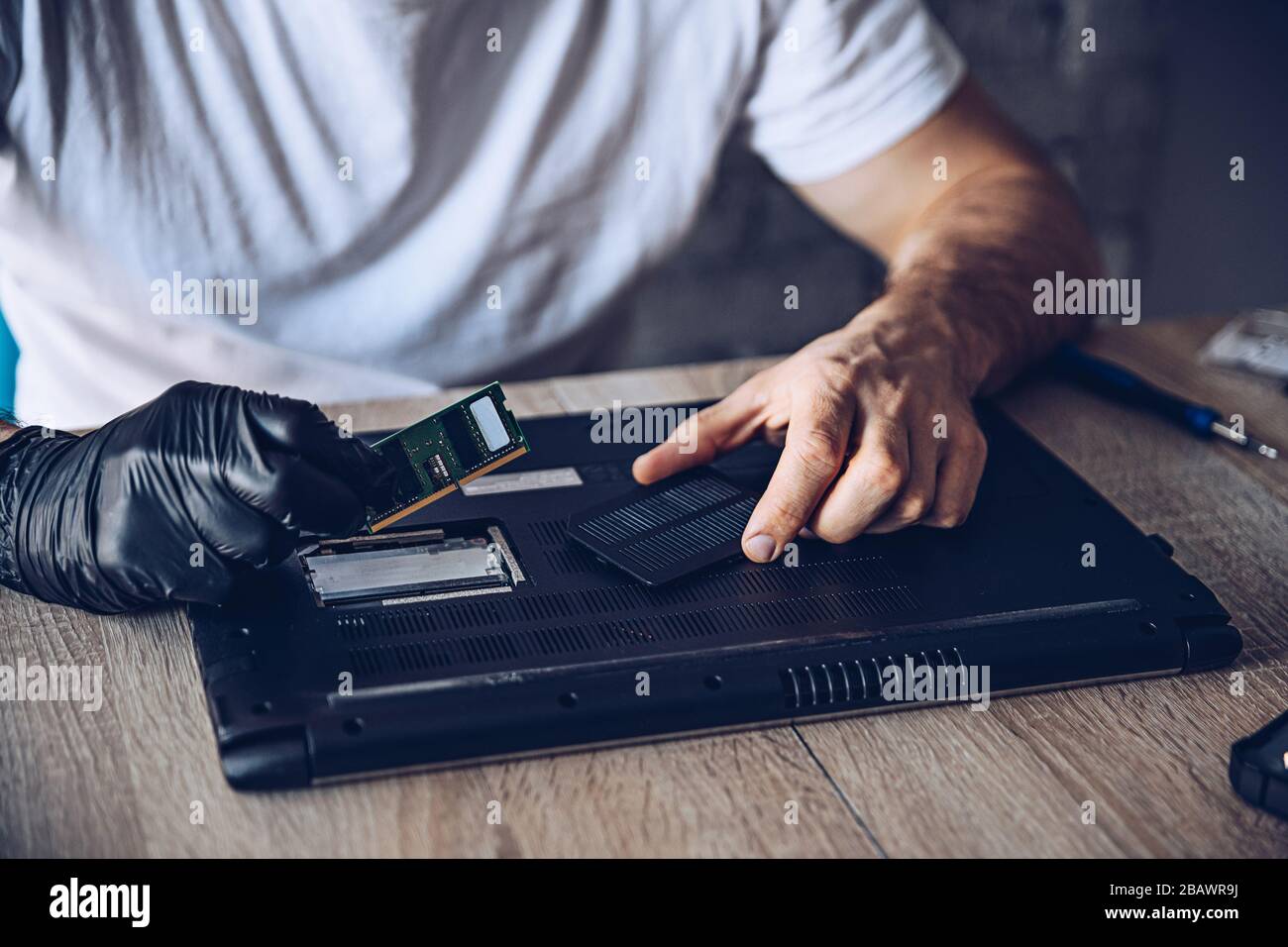 Technician installing new RAM module into the memory slot Stock Photo ...