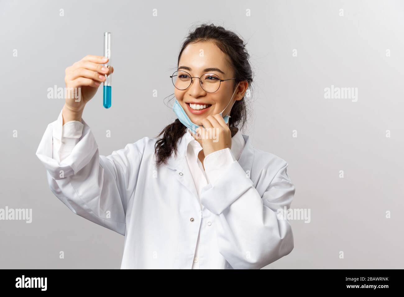 Doctors, infectionist, research and covid19 concept. Portrait of relieved and plesed asian girl take-off medical mask and smiling satisfied looking at Stock Photo