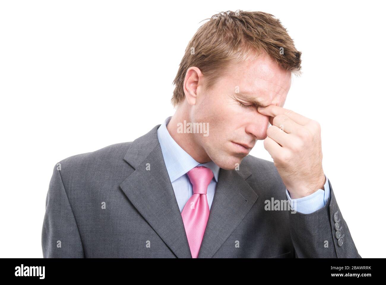 Stressed businessman pinching the bridge of his nose to alleviate his