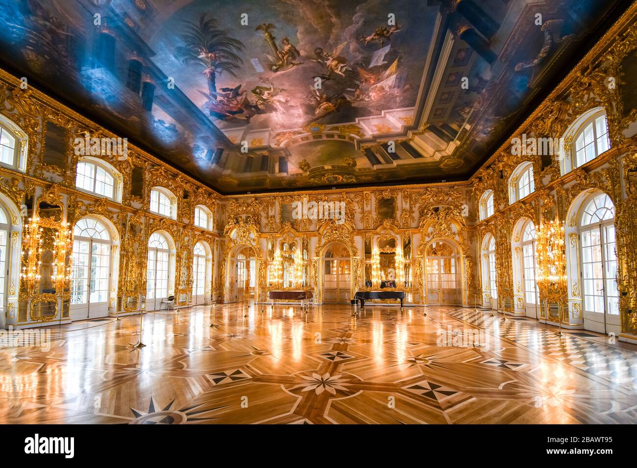 An ornate golden interior ballroom with a grand piano inside the Rococo Catherine Palace at Pushkin near St. Petersburg, Russia. Stock Photo