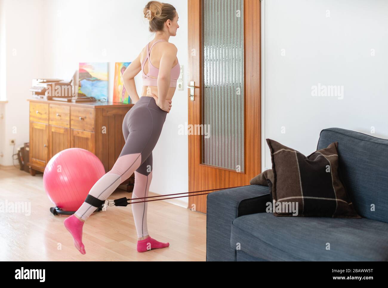 Beautiful woman staying fit during quarantine doing fitness exercise at home Stock Photo