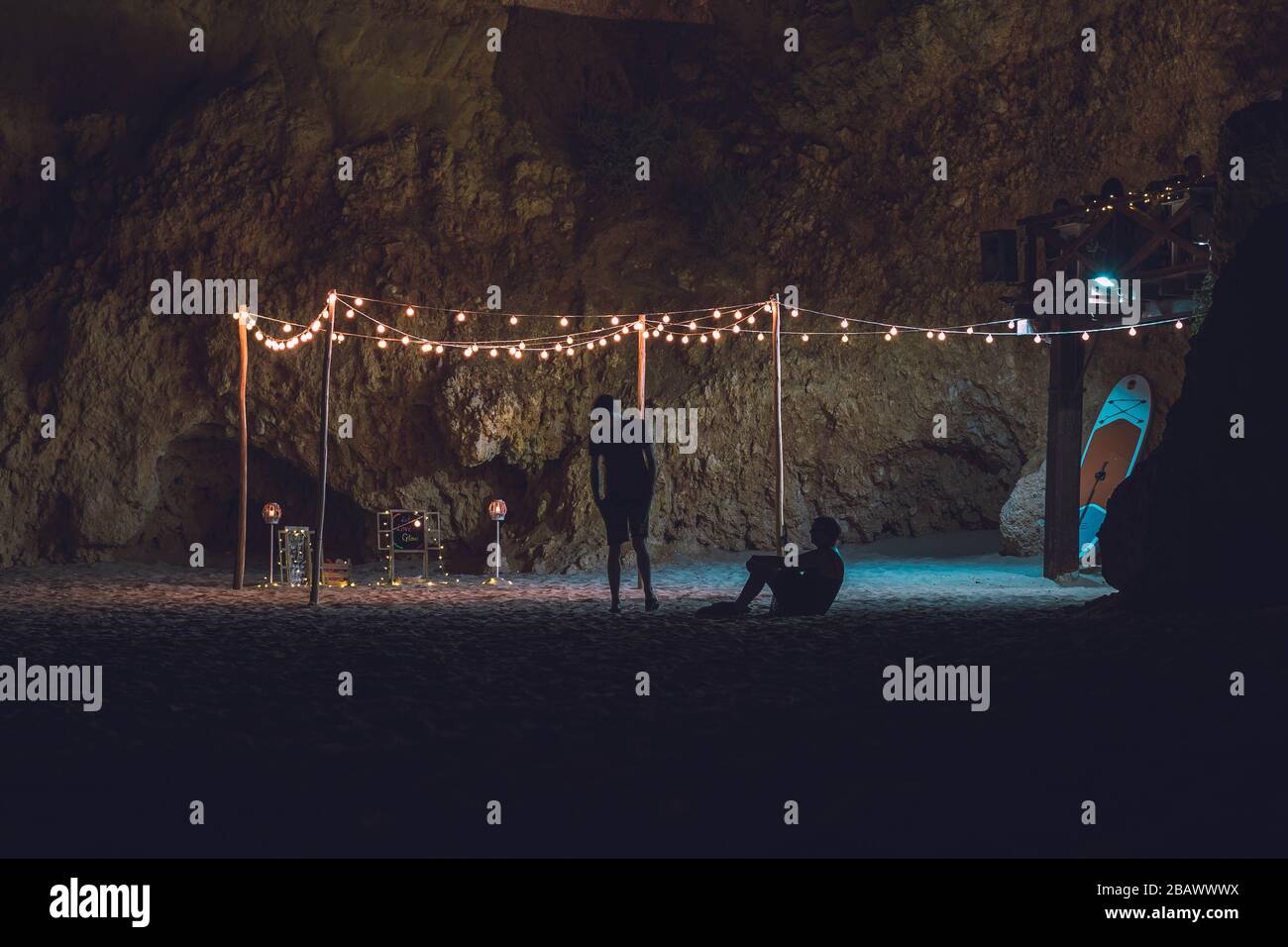 open air cinema with projector on the beach. silhuette people enjoing