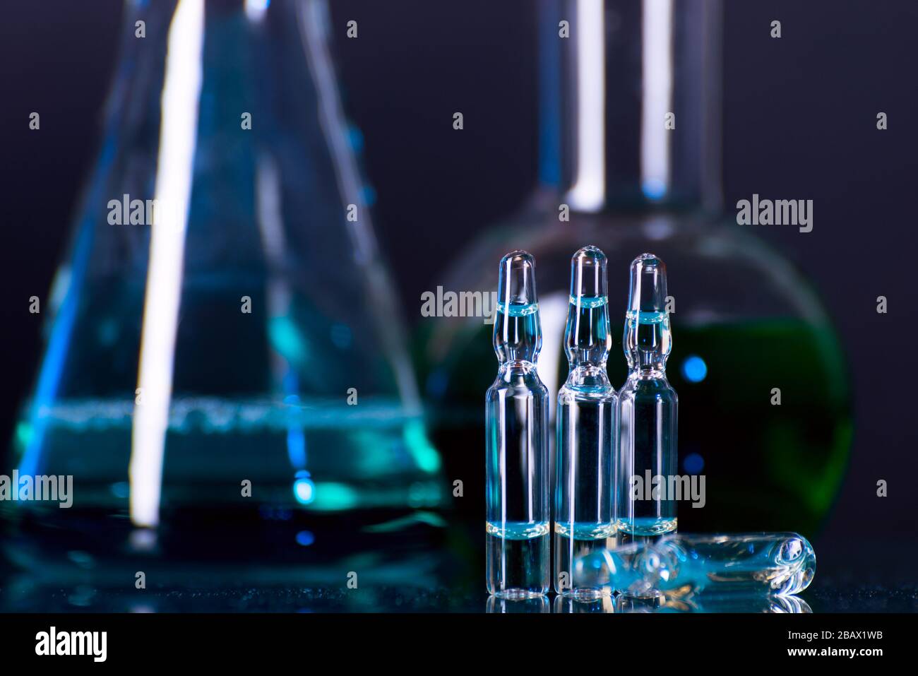 Glass ampoules with liquid for injection against lab flasks in dark